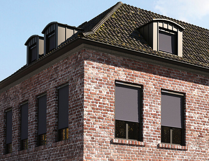 Backsteinhaus mit geschlossenen MHZ SOLIX Aussenrollos an den Fenstern der oberen Etage.