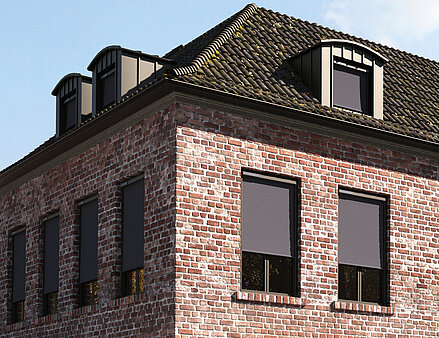 Backsteinhaus mit geschlossenen MHZ SOLIX Aussenrollos an den Fenstern der oberen Etage.