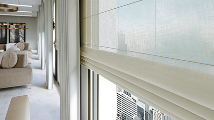 Elegante, halbtransparente Raffrollos und fliessende Vorhänge in einem modernen Wohnraum mit bodentiefen Fenstern und Stadtblick.