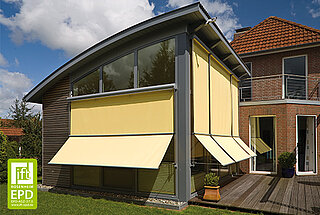 Ein modernes Wohnhaus mit grossen Glasflächen und mehreren gelben MHZ-Markisen, die senkrecht und ausgestellt angebracht sind.