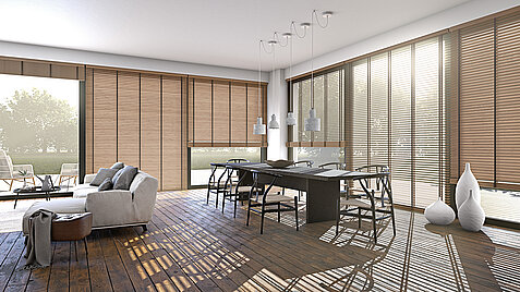 Heller Wohn-Essbereich mit Holzjalousien vor grossen Fenstern, Holzboden und moderner Einrichtung.