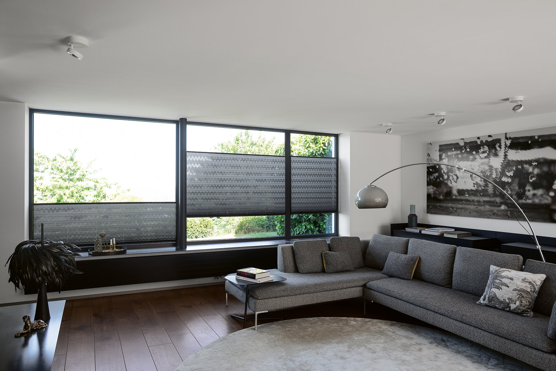 MHZ Plissee 4766 Dunkelgraue Plissees mit grafischem Muster in einem modern eingerichteten Wohnzimmer mit Ecksofa