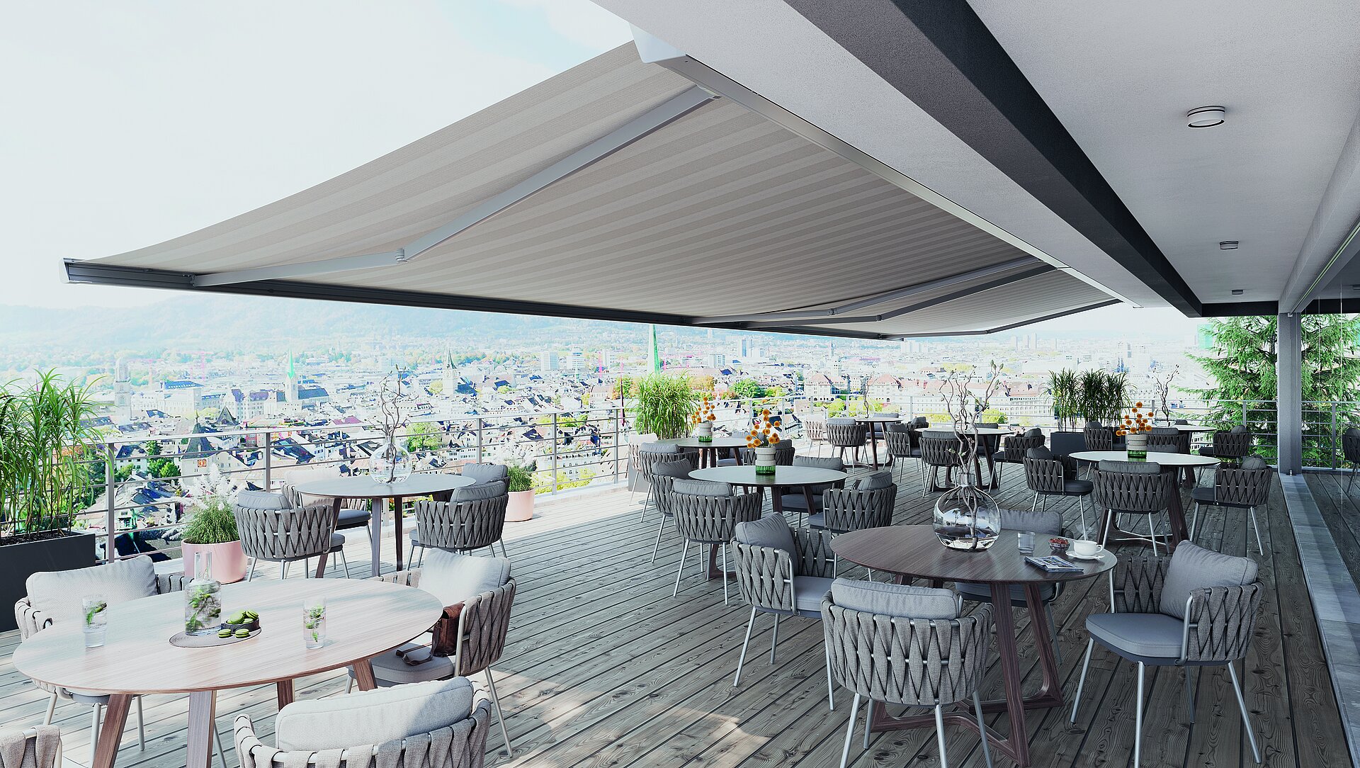 Grosse Markise beschattet Restaurantterrasse mit gedeckten Tischen und Blick auf Stadtlandschaft.
