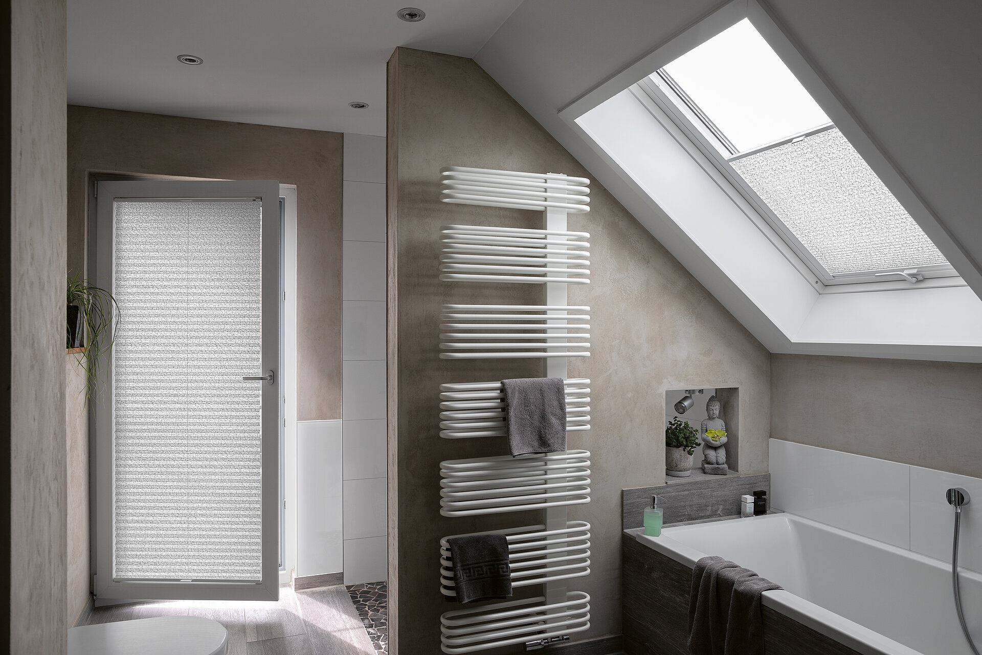 Modernes Badezimmer mit weissen Plissees an Tür und Dachfenster als Sichtschutz.
