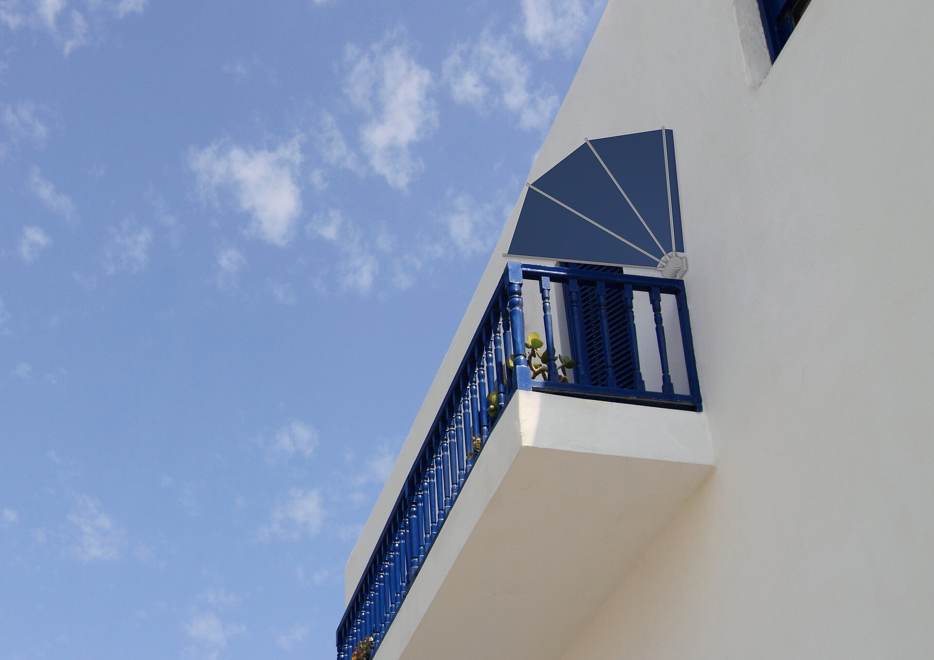 Balkon mit blauer Metallbrüstung und seitlich montierter fächerförmiger Markise an weisser Fassade
