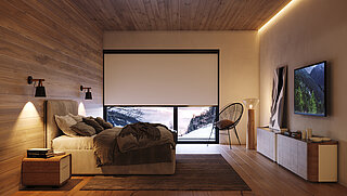 Modernes Schlafzimmer mit vollständig geschlossenem Verdunkelungsrollo vor einem grossen Panoramafenster. Raum mit Holzverkleidung, warmen Farben und alpinem Charakter.