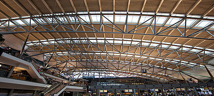Blick auf das moderne Glasdach mit MHZ-Beschattung in der lichtdurchfluteten Haupthalle des Hamburger Flughafens.