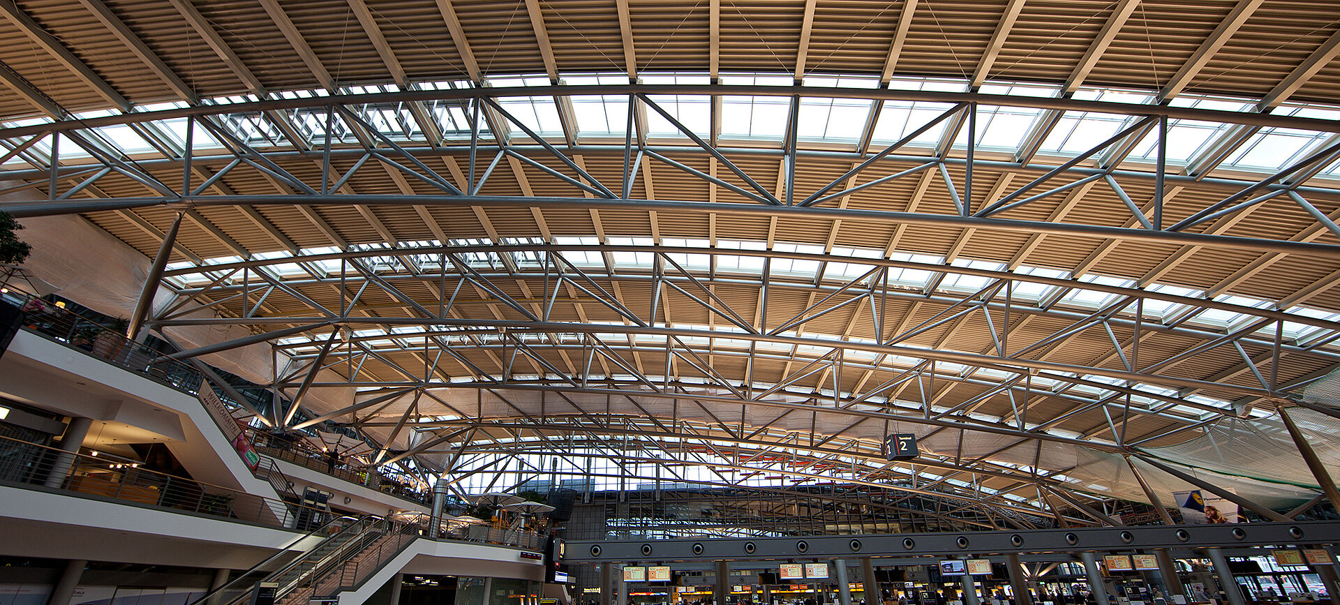 Blick auf das moderne Glasdach mit MHZ-Beschattung in der lichtdurchfluteten Haupthalle des Hamburger Flughafens.
