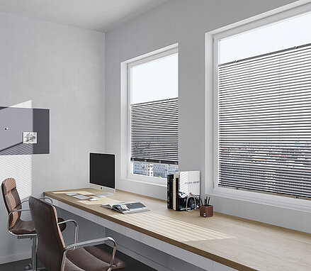 Büro mit zwei Fenstern und Jalousien. Horizontale Lamellen sorgen für blendfreies Arbeiten am Computer.