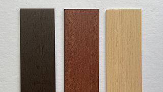 Drei Abachi-Holzmusterplatten in dunklem Braun, rötlichem Braun und hellem Beige nebeneinander.