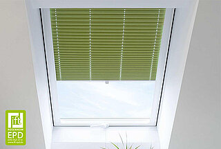 Grünes Plissee von MHZ in einem weissen Dachfenster, teilweise geschlossen zur Regulierung von Licht und Sicht.