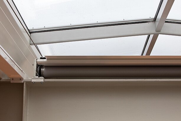 Detailaufnahme einer Gegenzuganlage k_oax unter einem Glasdach im Flughafen Hamburg, teilweise eingerollt.