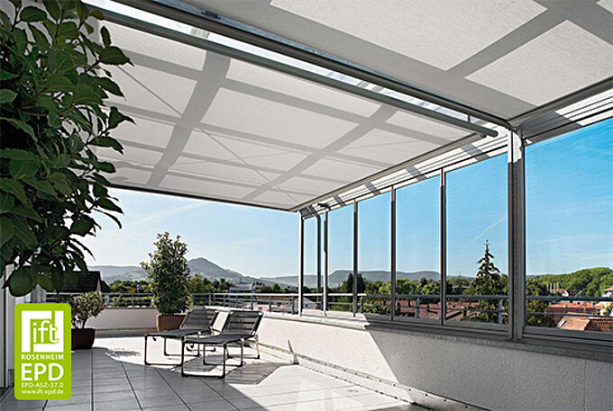 Eine sonnige Dachterrasse mit Glaseinfassung und textiler Horizontalbeschattung durch das MHZ-INTRA-System. Sonnenlicht wird diffus gefiltert.