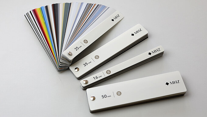 MHZ Farbfächer mit Lamellenmustern in 16, 25, 35 und 50 mm Breite für Jalousien in verschiedenen Farben.