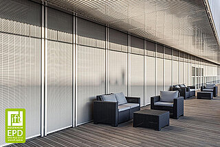 Moderne Fassade mit vertikalen Metallbehängen als Sonnenschutz. Davor befinden sich schwarze Outdoor-Sitzmöbel auf einer Holzterrasse unter einem schattenspendenden Dach.