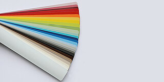 Farbfächer mit seidenmatten Lamellen aus der DIM Kollektion in neutralen, kräftigen und bunten Farbtönen.