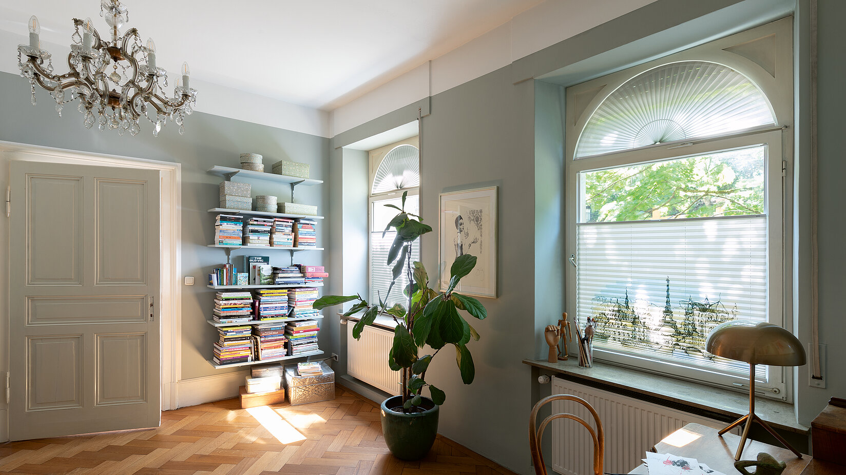 Arbeitszimmer mit Rundbogenfenstern und massgefertigten Plissees mit Paris-Motiv – dekorativer Sicht- und Sonnenschutz.