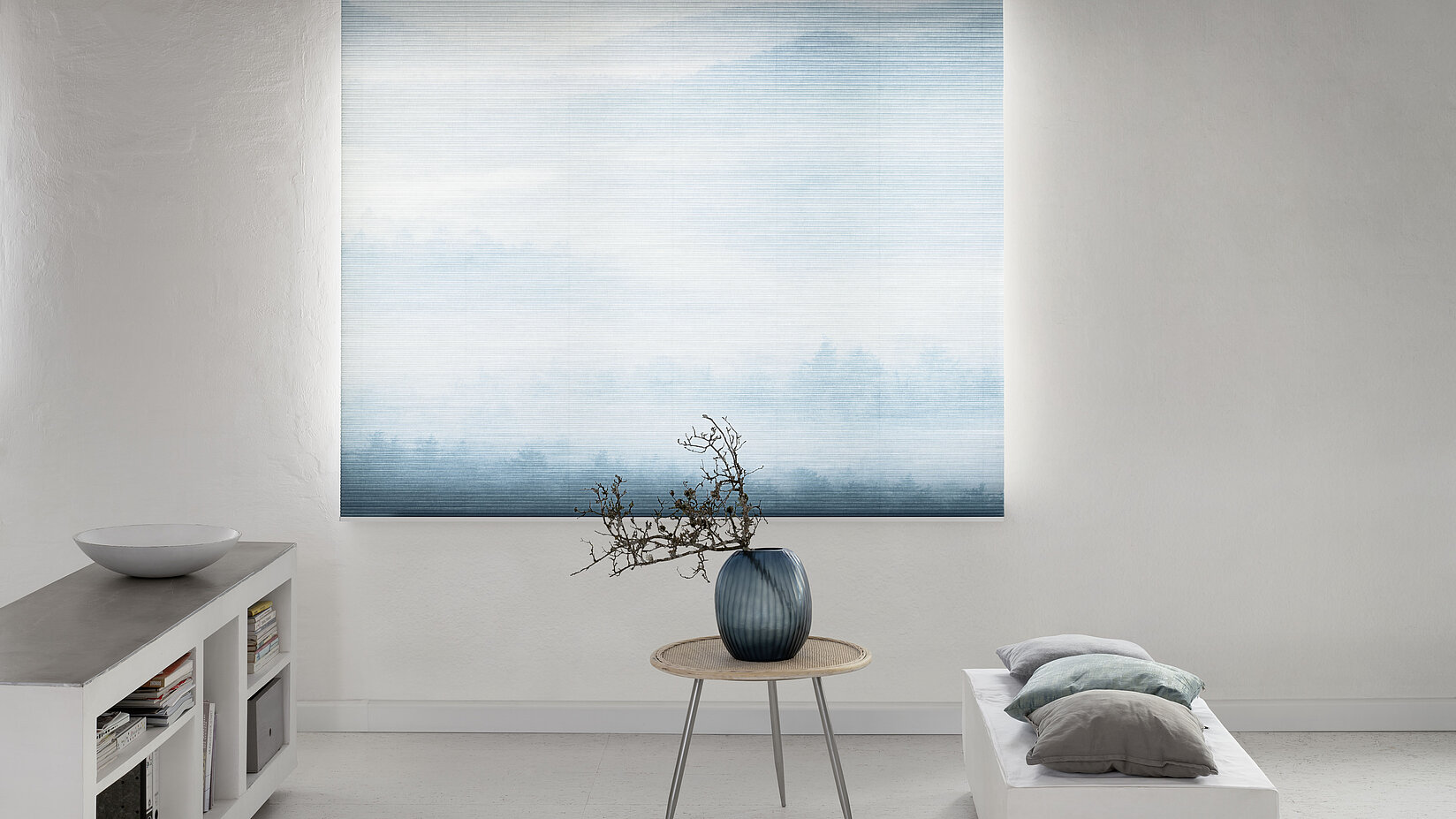 MHZ Wabenplissee mit sanftem Landschaftsmotiv in Blau, vor einem hellen Raum mit minimalistischer Einrichtung.