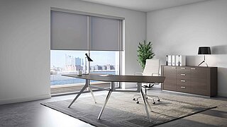 Modernes Büro mit bodentiefem Fenster und grauen lichtdurchlässigen Rollos als Blendschutz am Schreibtisch