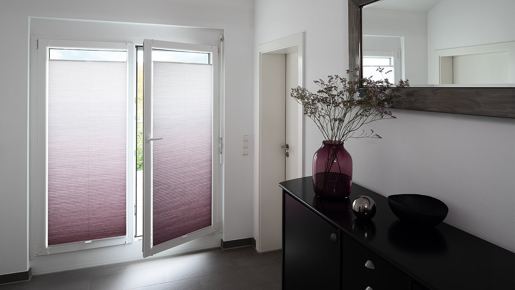 MHZ Wabenplissees mit Farbverlauf in Lila-Weiss an zwei Terrassentüren in einem modernen Flur mit schwarzer Konsole.