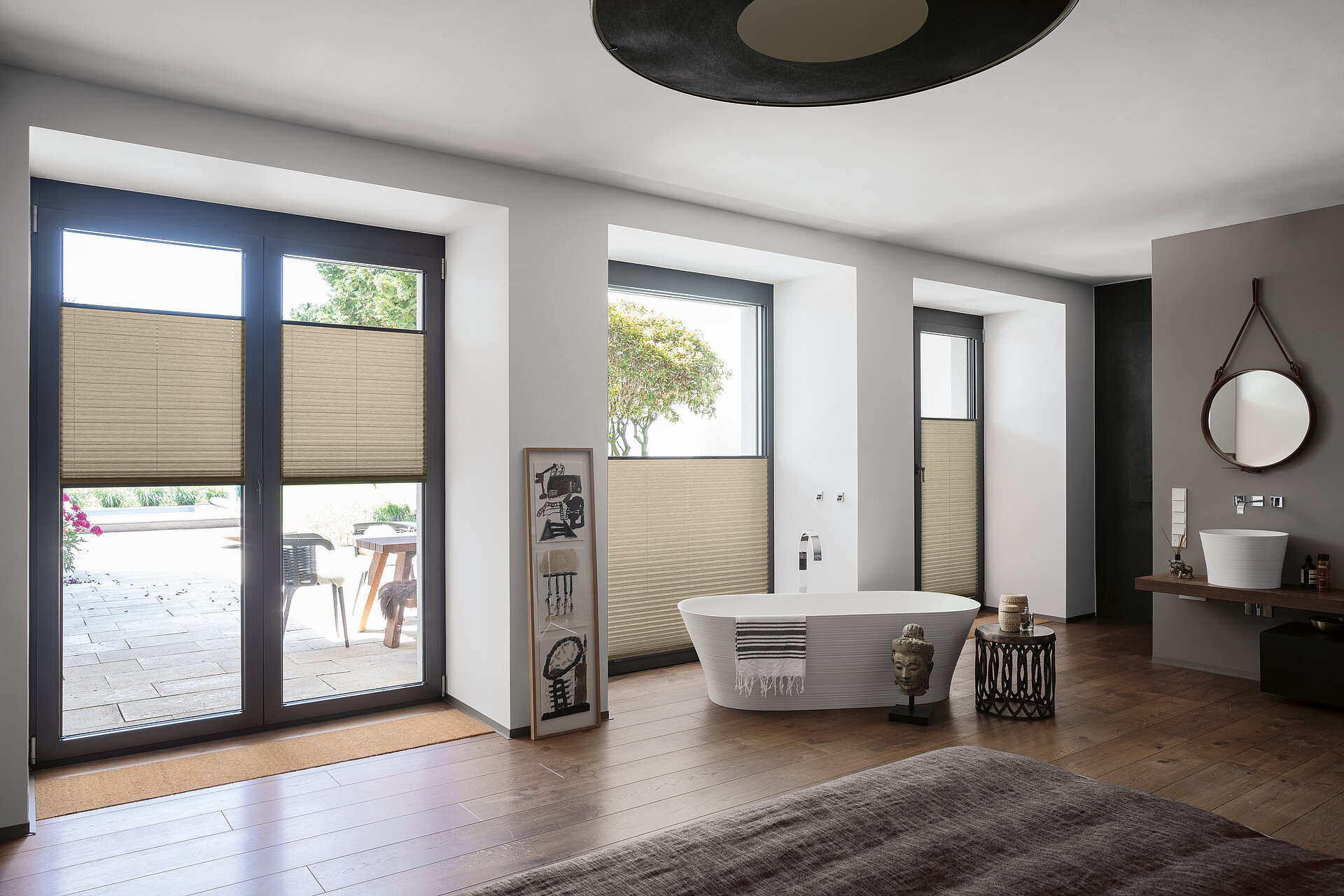 Beige Plissees im unteren Fensterbereich als Sichtschutz in modernem Badezimmer mit freistehender Badewanne.